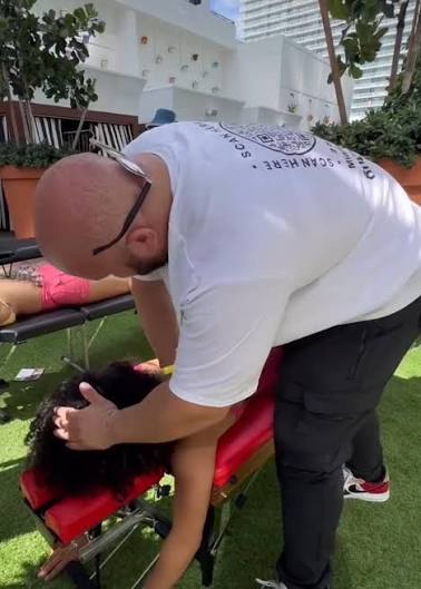 Chiropractic treatment on a portable table during an outdoor event